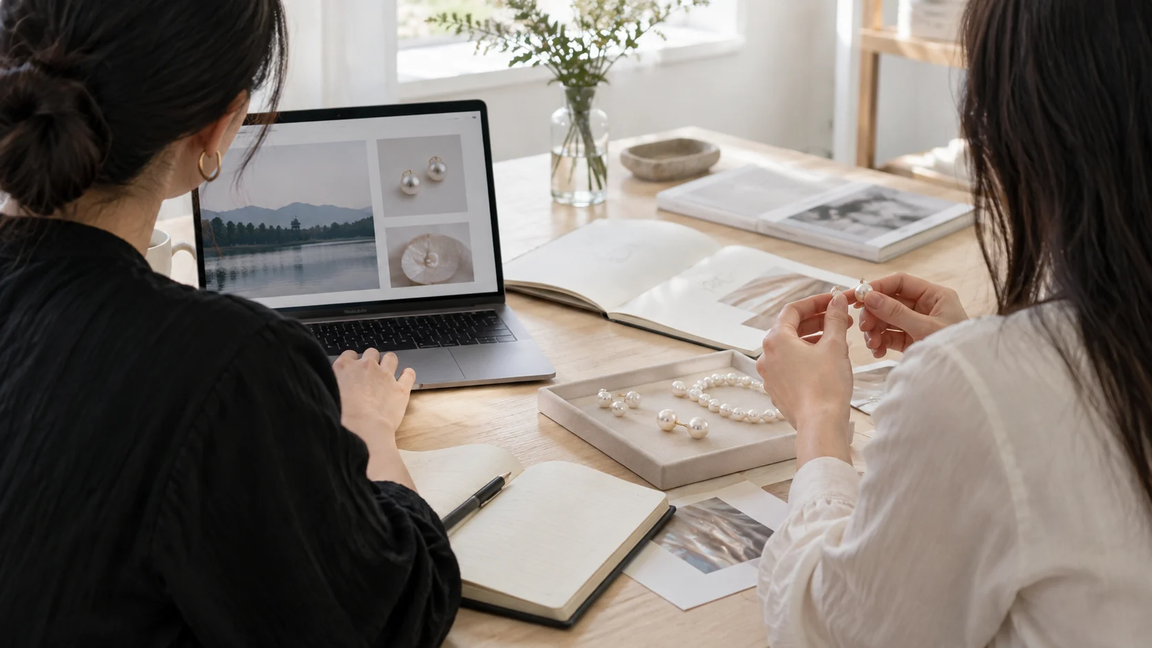 Concept image of two collaborators reviewing pearl jewelry and digital product information
